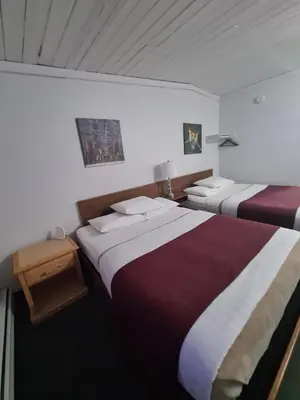 two beds in a hotel room with two bedsvisor at Sundowner Motel in Cache Creek
