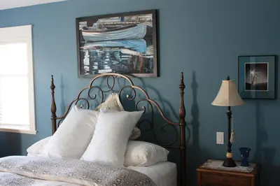 a blue bedroom with a bed with white pillows at Eaglenest Manor Cowichan in Duncan