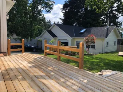 a wooden deck with a bench in front of a house at Eaglenest Manor Cowichan in Duncan