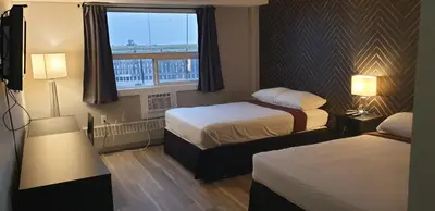 a hotel room with two beds and a window at New Frontier Hotel in Coronation