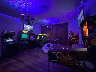 a room with a bunch of video games and purple lights at New Frontier Hotel in Coronation