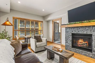 a living room with a couch and a fireplace at Spring Creek Luxury King One Bedroom at White Spruce Lodge in Canmore