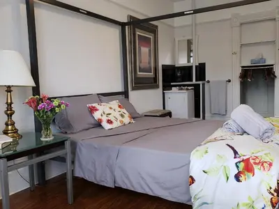 a bedroom with a bed and a table with flowers on it at Vancouver Hideaway Guesthouse in Vancouver