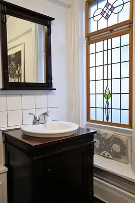 a bathroom with a sink and a mirror and a window at Vancouver Hideaway Guesthouse in Vancouver