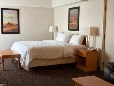 a hotel room with a large bed and a couch at Westlock Inn & Conference Centre in Westlock