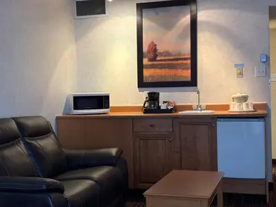 a waiting room with a couch and a microwave at Westlock Inn & Conference Centre in Westlock