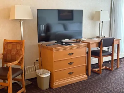 a hotel room with a television and a dresser with a desk at Westlock Inn & Conference Centre in Westlock