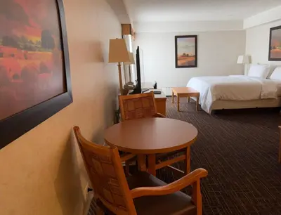 a hotel room with a bed and a table and chairs at Westlock Inn & Conference Centre in Westlock