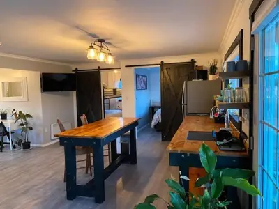 a living room with a wooden table in a room at Sunrise Cabin secluded beach front accommodation in Sandspit