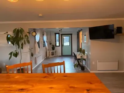 a dining room with a table and chairs and a living room at Sunrise Cabin secluded beach front accommodation in Sandspit