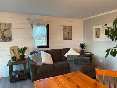 a living room with a couch and a table at Sunrise Cabin secluded beach front accommodation in Sandspit
