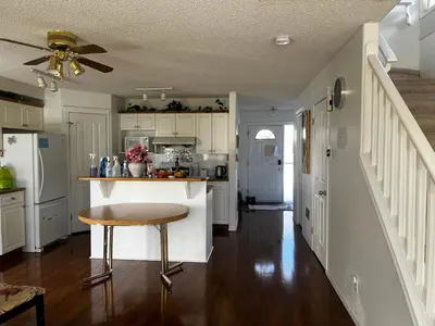 a kitchen with white cabinets and a table in it at Hidden valley treehouse home! in Calgary