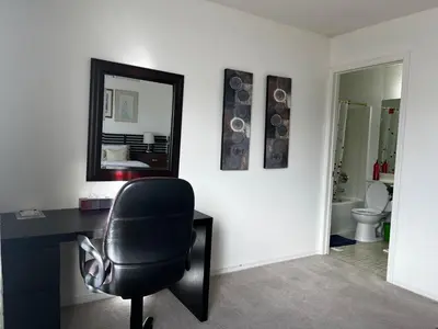 a office with a black chair and a mirror at Hidden valley treehouse home! in Calgary