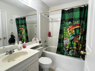 a bathroom with a sink and a toilet and a shower curtain at Hidden valley treehouse home! in Calgary