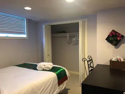 a bedroom with a bed and a desk and a table at Hamptons Rose garden family! in Calgary