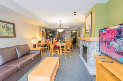 a living room with a couch and a fireplace at Mountain View Escape - Copperstone 2BR & Hot Tub in Canmore