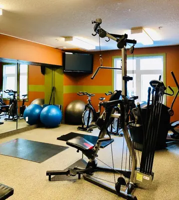 a gym with bikes and exercise equipment in a room at WindTower Resort - 1 Bed Hotel Room 166 in Canmore