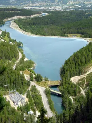 an aerial view of a lake with a bridge and trees at Anniversary and Honeymoon 1 Bedroom Suite 168 in Canmore