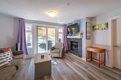 a living room with a couch and a fireplace at Anniversary and Honeymoon 1 Bedroom Suite 168 in Canmore