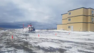 a helicopter parked next to a building in the snow at The View Hotel in Fort Saint James