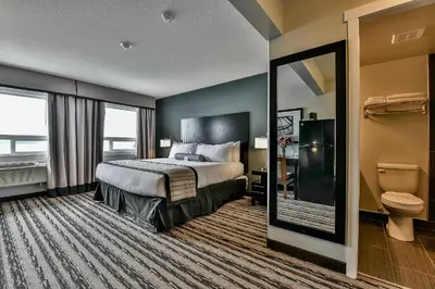 a hotel room with a bed and a toilet at The View Hotel in Fort Saint James