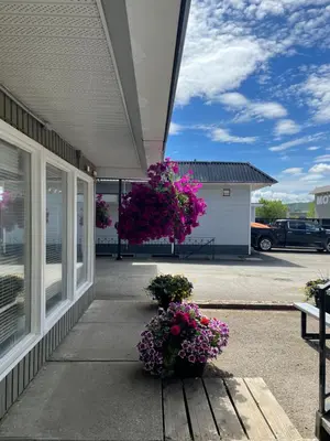 a building with two potted flowers on the sidewalk at Anavada Inn & Suites - Prince George in Prince George