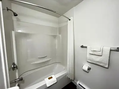 a white bathroom with a shower and a bath tub at Anavada Inn & Suites - Prince George in Prince George