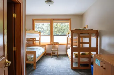 a bedroom with two bunk beds and a window at Whalers Guesthouse in Tofino