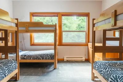 a bedroom with bunk beds and a window at Whalers Guesthouse in Tofino
