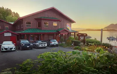 a large building with cars parked in front of it at Whalers Guesthouse in Tofino