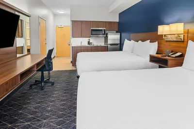 a hotel room with two beds and a desk at Park Inn by Radisson, Kelowna in Kelowna