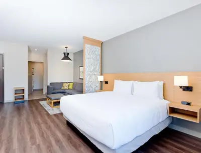 a bedroom with a large white bed and a couch at Hyatt Place Kelowna in Kelowna