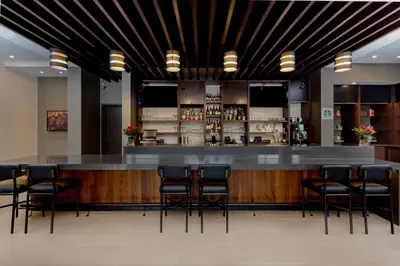 a bar in a restaurant with black stools at Hyatt Place Kelowna in Kelowna