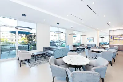 a restaurant with tables and chairs and windows at Hyatt Place Kelowna in Kelowna