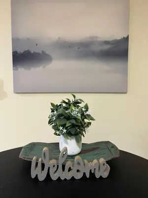 a sign that says welcome with a plant in a vase at Wildflower Suite in Whistler