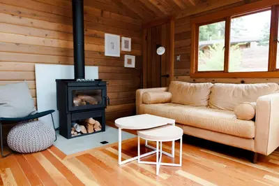 a living room with a couch and a stove at Bodega Ridge & Cove Cabins in Fernwood