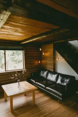 a living room with a black leather couch and a coffee table at Bodega Ridge & Cove Cabins in Fernwood