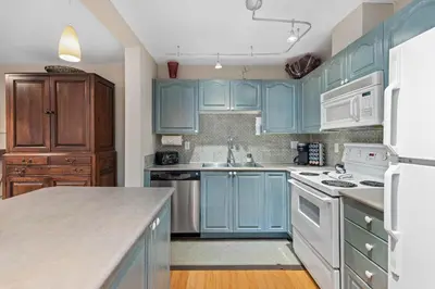 a blue kitchen with white appliances and blue cabinets at Stoney Creek Sunpath by Whistler Premier in Whistler