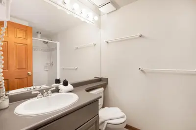 a white bathroom with a sink and a toilet at Stoney Creek Sunpath by Whistler Premier in Whistler