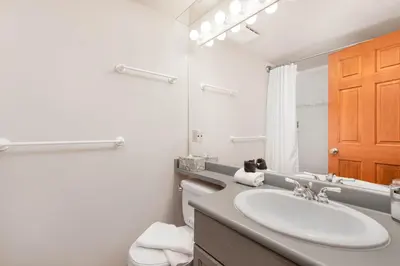 a bathroom with a sink and a toilet and a mirror at Stoney Creek Sunpath by Whistler Premier in Whistler