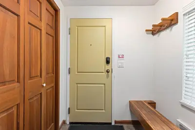 a hallway with a green door and a bench at Stoney Creek Sunpath by Whistler Premier in Whistler