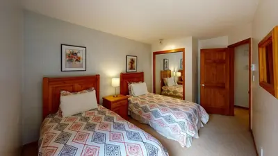 a bedroom with two beds and a mirror at Painted Cliff by Whistler Premier in Whistler