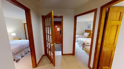 a room with two beds and a door with a mirror at Painted Cliff by Whistler Premier in Whistler