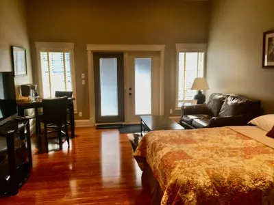 a bedroom with a bed and a desk and a couch at Kootenay Wild Guest Suites in Nelson