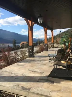 a patio with chairs and a view of the water at Kootenay Wild Guest Suites in Nelson