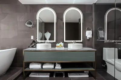 a bathroom with two sinks and a tub and mirrors at Versante Hotel in Richmond