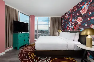 a bedroom with a bed and a flat screen tv at Versante Hotel in Richmond