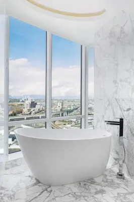 a white bathroom with a tub in front of a window at Versante Hotel in Richmond