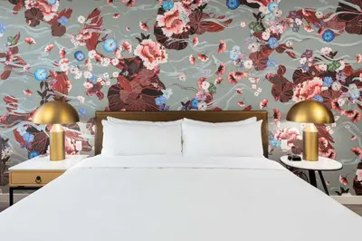 a bedroom with a bed and a floral wallpaper at Versante Hotel in Richmond