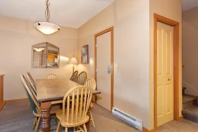 a dining room with a wooden table and chairs at Symphony by Whistler Premier in Whistler